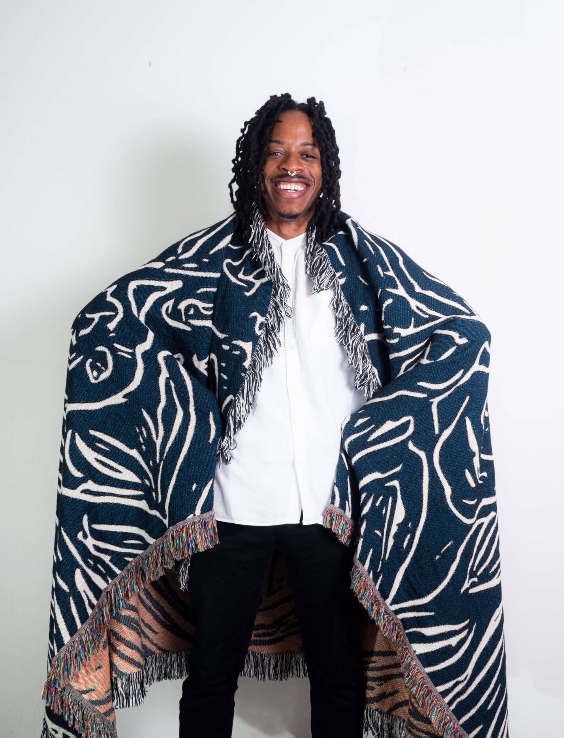 Kanaga print blanket draped over my shoulders. Its a peachy orange in the inside and navy blue on the outside.