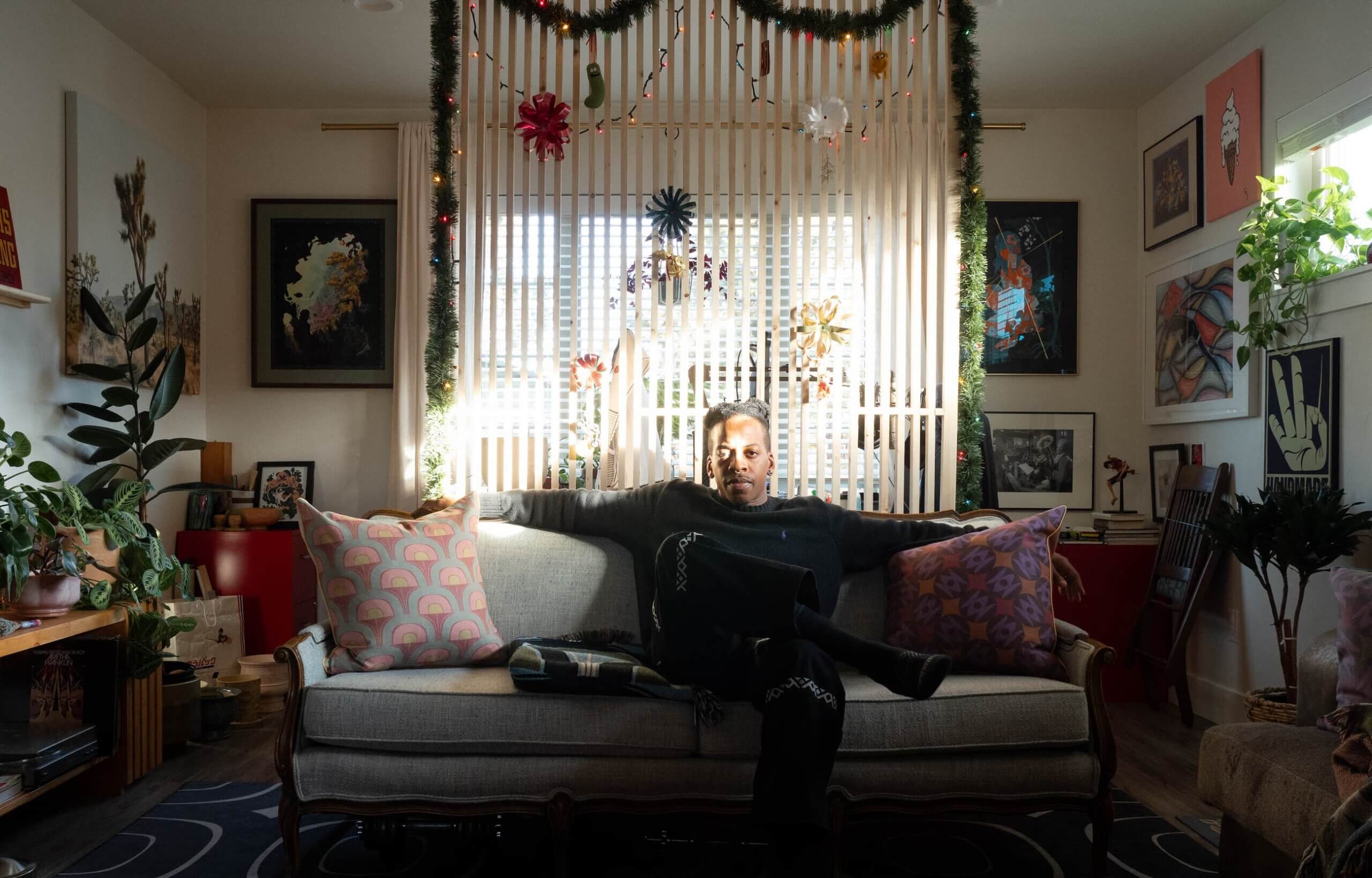 Phillip sitting on the couch of his last rental he decorated