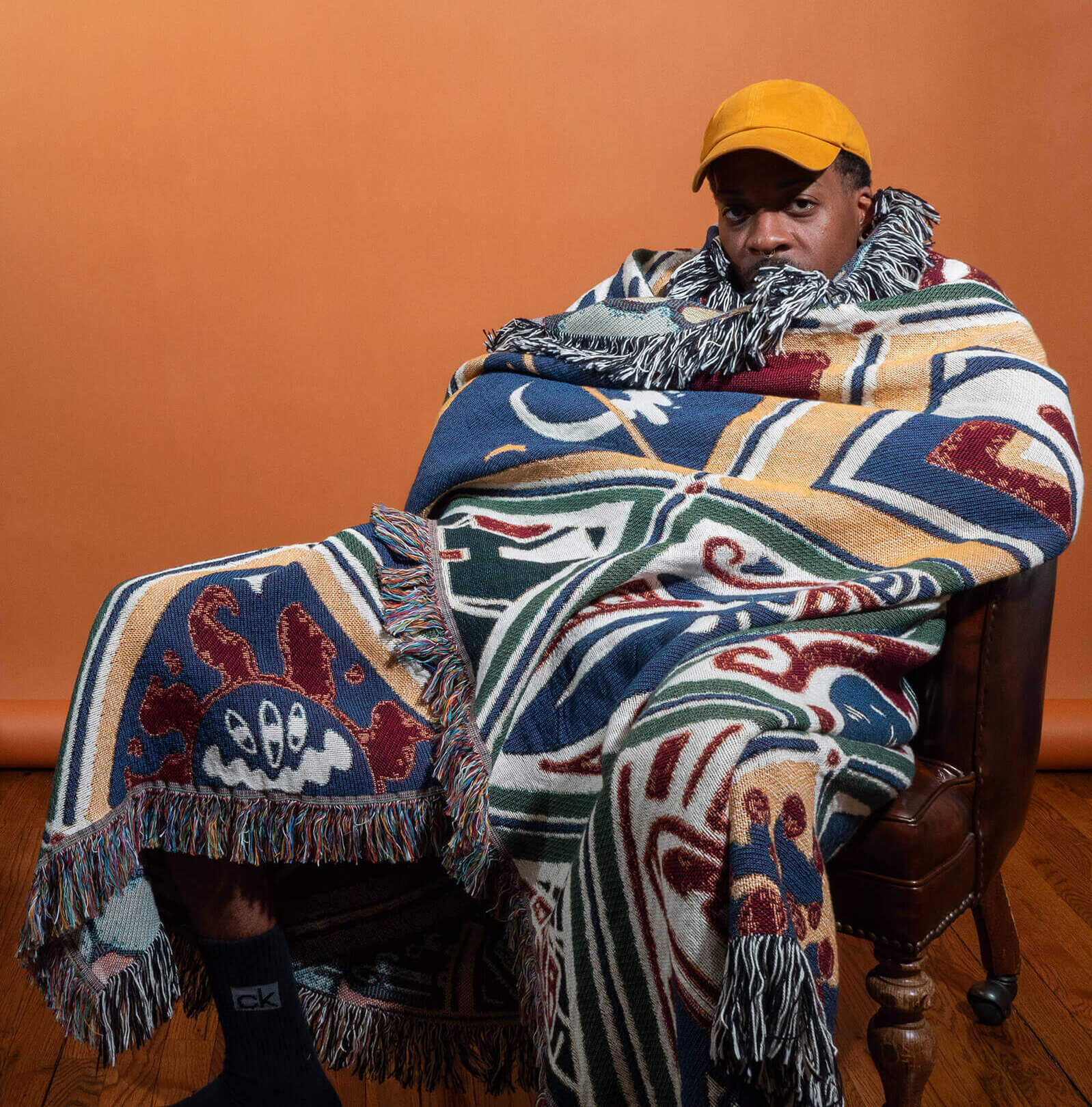 Phillip in a chair wrapped in heritage blanket