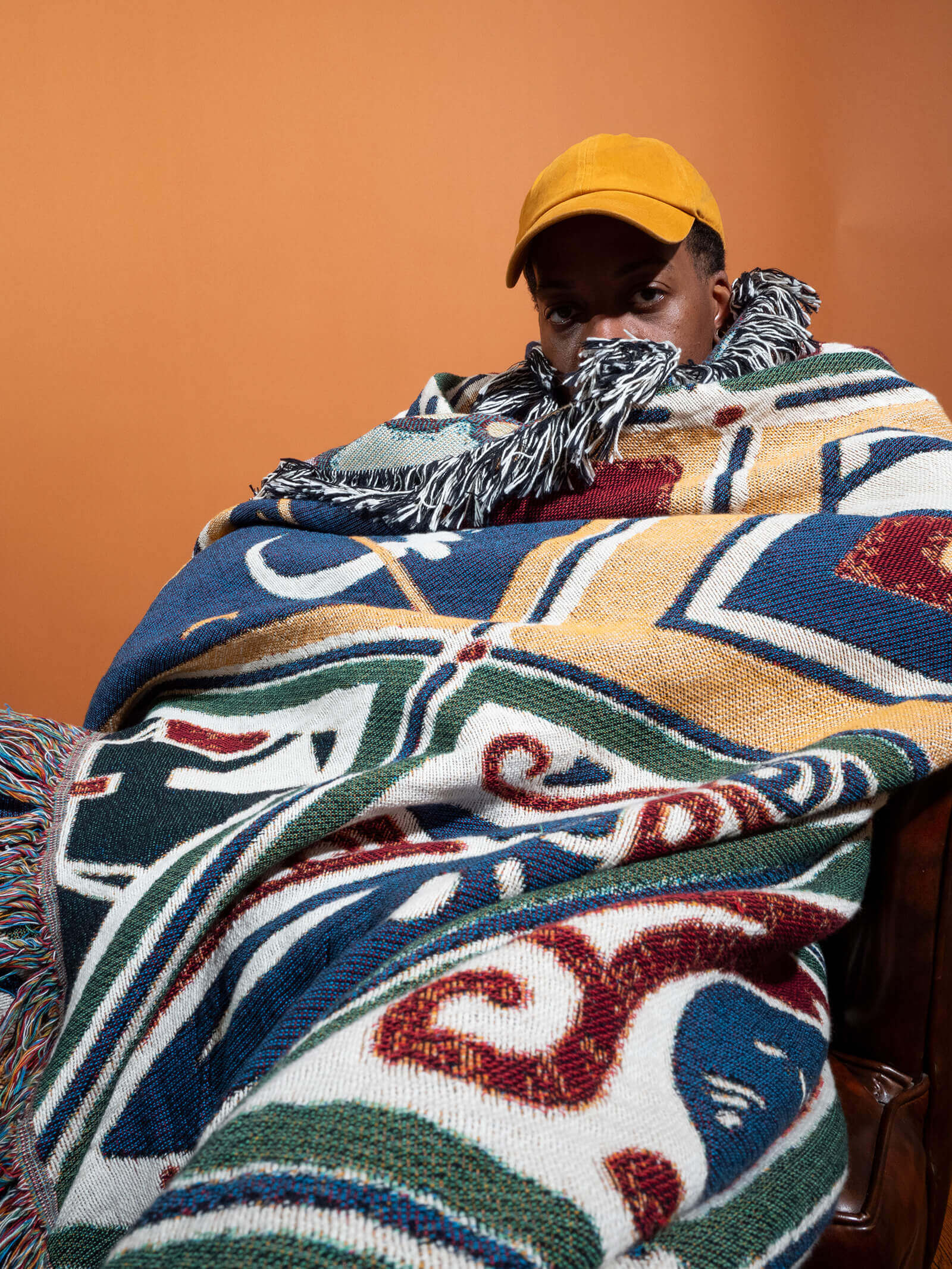 Phillip in a chair wearing heritage blanket
